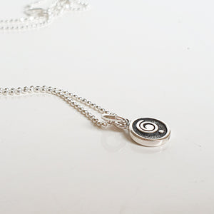 Silver necklace with a spiral pendant on a white background