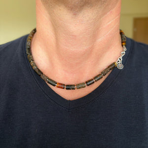 Necklace with beads worn by a person against a neutral background