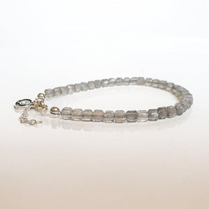 Beaded bracelet with a chain on a light background