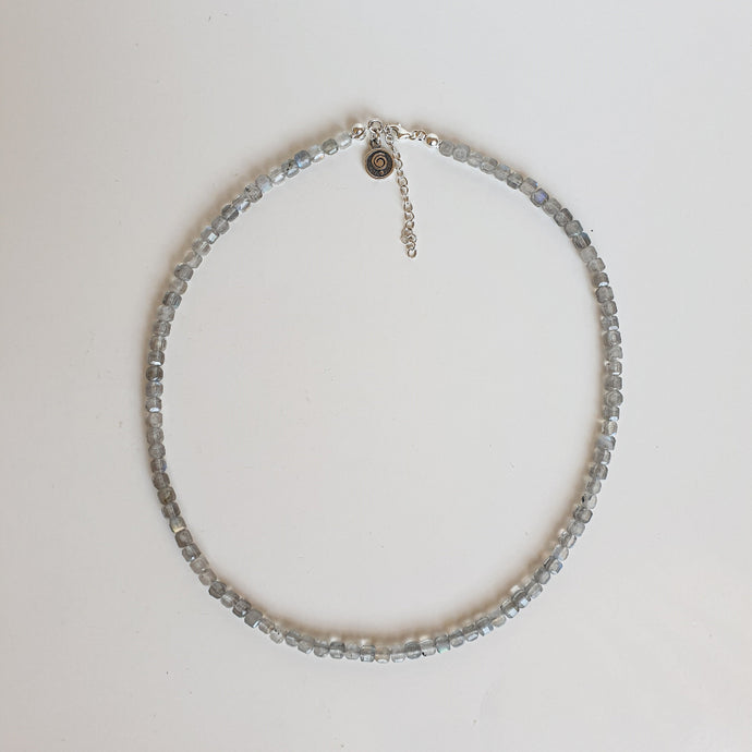 Necklace with small beads on a light gray background