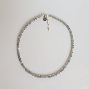 Necklace with small beads on a light gray background