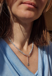 Close-up of a woman wearing a diamond necklace with a blurred background
